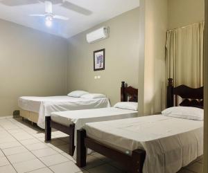 ein Krankenhauszimmer mit 2 Betten und einem Ventilator in der Unterkunft Ouro Hotel in Ourinhos