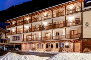 a hotel in the snow at night at Tyrol Mountain Aparts - Urlaubsresort Hafele in Sankt Jakob in Defereggen