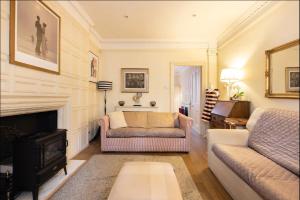 a living room with a couch and a fireplace at Pass the Keys Cosy 1 bedroom flat in Knightsbridge in London