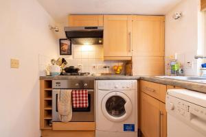 a kitchen with a washing machine and a sink at Pass the Keys Cosy 1 bedroom flat in Knightsbridge in London