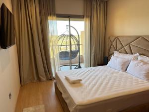 Schlafzimmer mit einem Bett und einem Fenster mit Aussicht in der Unterkunft Agate 212 Lovely 2-bedrooms apartment with pool & golf view in Marrakesch