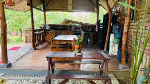 a patio with tables and benches in a building at Pondok sari homestay in Ungasan