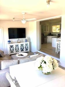 a living room with a couch and a table with flowers at SALT @ North Beach WALLAROO (absolute beachfront) in Wallaroo