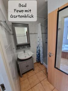 a bathroom with a sink and a mirror and a shower at Küstenhostel in Klausdorf Mecklenburg Vorpommern
