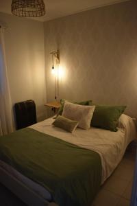 Un dormitorio con una cama grande con almohadas verdes y blancas en Roca blanca en Tandil