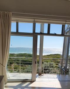 a view of the ocean from a room with a large window at Beachfront 3-bedroom with Robben Island views in Cape Town