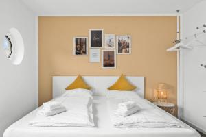 uma cama com lençóis brancos e almofadas amarelas em Entspanntes Wohnen in Düren em Düren - Eifel