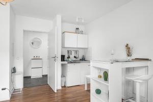 uma cozinha branca com armários brancos e piso em madeira em Entspanntes Wohnen in Düren em Düren - Eifel