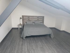 um quarto com uma cama grande e uma cabeceira em madeira em Le Coustalou em Livinhac-le-Haut