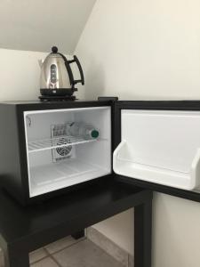 a black table with an open refrigerator and a kettle at casa matteo de haan Grote straat 152 in Vlissegem