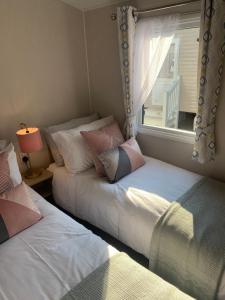 2 camas en una habitación con ventana en Number 57 Brynteg, en Caernarfon
