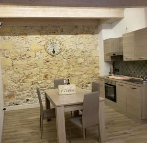 a kitchen with a table and chairs and a clock on a wall at B&B GUEST HOUSE TZIA e UDRONI in Ossi +12 photos