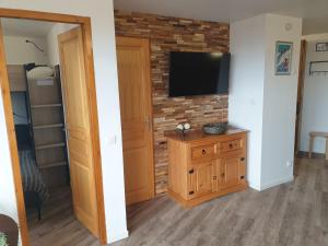a living room with a television on a brick wall at Chalet L'Hermine in Val Thorens