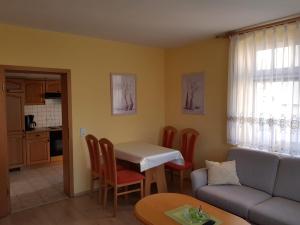 ein Wohnzimmer mit einem Tisch und einem Sofa in der Unterkunft Ferienwohnung Karlguth in Neustadt in Sachsen