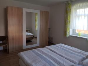 um quarto com uma cama grande e um espelho em Ferienwohnung Karlguth em Neustadt in Sachsen