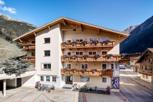 a hotel in the mountains with flowers on the balconies at Apart Gletscherblick in Sölden