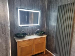 uma casa de banho com 2 lavatórios e um espelho em Stunning 1 Bedroom Lodge em Welshpool