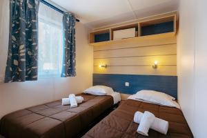 1 dormitorio con 2 camas y ventana en VVF Pointe Bretagne, Argol en Argol