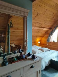 a bedroom with a bed and a large mirror at Chambre d'hôtes - Le jardin des Patissons in La Foret Du Parc