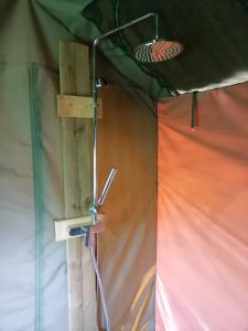a room in a tent with a shower at Chosen Glamping Tents in Graskop