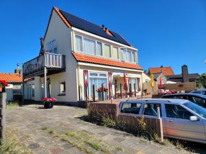 un coche aparcado frente a una casa en Pension Canberra, en Bergen aan Zee