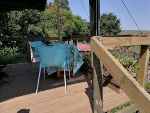 a deck with a blue chair and an umbrella at Chosen Glamping Tents in Graskop