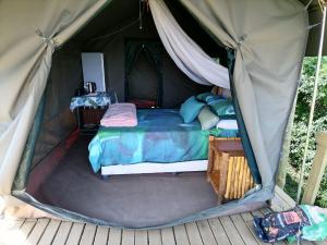 1 dormitorio en una tienda de lona con 1 cama en Chosen Glamping Tents, en Graskop