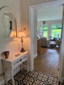 a room with a table with a lamp and a living room at Adorable one bedroom apartment with balcony in Newtownards