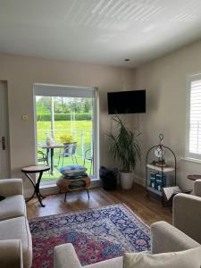 a living room with a couch and a tv and a table at Adorable one bedroom apartment with balcony in Newtownards
