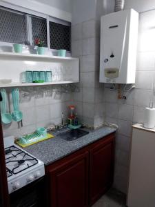 a small kitchen with a sink and a stove at Departamento Ciudad Mendoza in La Cieneguita