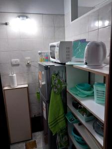 a small kitchen with a refrigerator and a microwave at Departamento Ciudad Mendoza in La Cieneguita