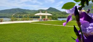 a garden with a gazebo and a body of water at Family Hotel Belvedere in Dŭlgopol