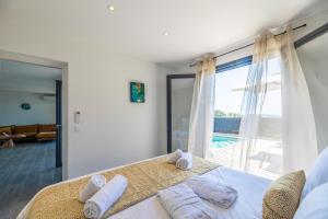 een slaapkamer met een bed met handdoeken erop bij Résidence Pierre & Vacances Premium Les Terrasses d'Arsella in Porto-Vecchio