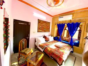 a bedroom with a bed and a table and a window at Hotel Murad Haveli Jaisalmer in Jaisalmer