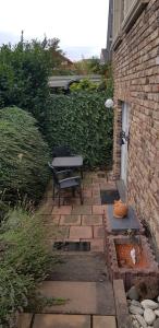 un patio avec une table et un banc à côté d'un bâtiment dans l'établissement ruhige Ferienwohnung in Waldnähe, à Rheinbach