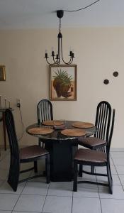 une table à manger avec des chaises et un lustre dans l'établissement ruhige Ferienwohnung in Waldnähe, à Rheinbach