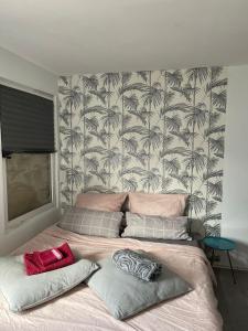 1 dormitorio con 1 cama grande y papel pintado de palmeras en DW_Bungalow am schönen Badesee Grünewalder Lauch en Lauchhammer