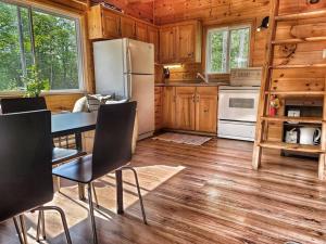 Ompah的住宿－Juniper Cabin- Waterfront retreat on Mosque Lake，厨房配有冰箱和桌椅