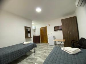 a room with two beds and a table and a kitchen at Omar Apartment in Wadi Musa