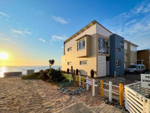 a house on the beach next to the ocean at Waterfront Edge B5 in Swakopmund