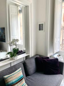 uma sala de estar com um sofá e duas janelas em Casa del corso em Acireale
