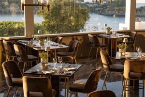 a restaurant with tables and chairs and a large window at Hotel Cala Moresca in Bacoli