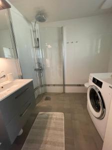 uma casa de banho com uma máquina de lavar roupa e um lavatório em Charmigt hus på Vindö em Estocolmo