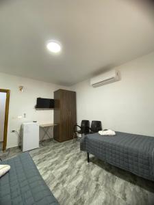 a bedroom with a bed and a desk and a tv at Omar Apartment in Wadi Musa