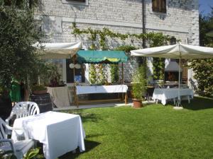 a garden with white tables and umbrellas on the grass at Lataria dei Magredi in Vivaro