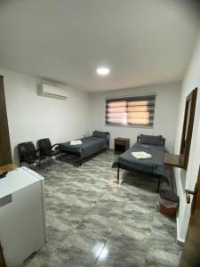 Omar Apartment في وادي موسى: غرفة معيشة مع كنب وكراسي في غرفة