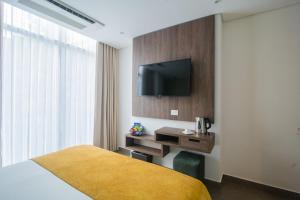 um quarto de hotel com uma cama e uma televisão na parede em Hotel Zi One Luxury em Cartagena das Índias