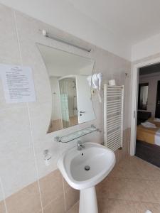 y baño con lavabo y espejo. en Hotel City Center en Braşov