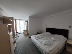 a bedroom with a white bed in a room at Hotel City Center in Braşov