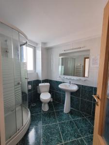 a bathroom with a toilet and a sink and a shower at Hotel City Center in Braşov